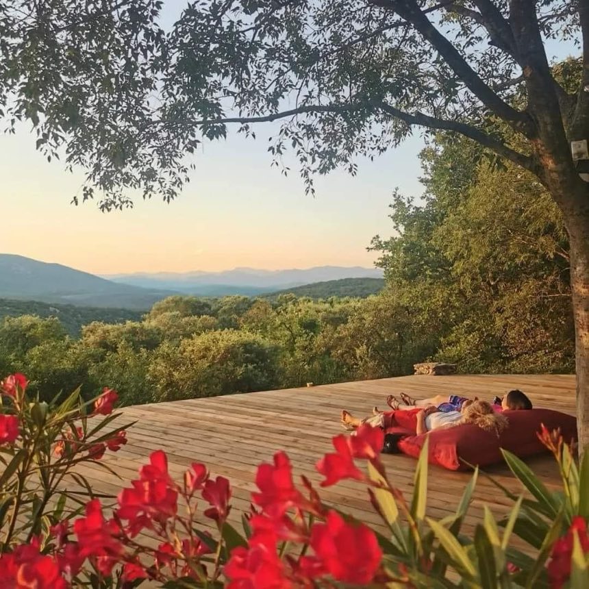 Terrasse en bois au coucher du soleil, face aux collines